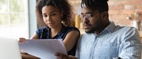 Millennial married couple reading about unsecured personal loans together.