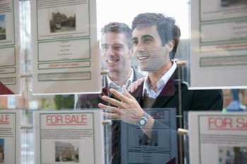 Couple looking into estate agents window