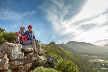 Senior couple resting on a mountain hike