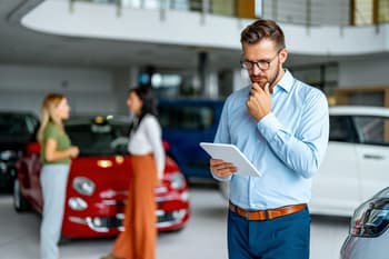 Person looking at tablet at car dealership