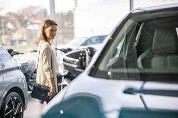 Woman browsing vehicles at a car dealership