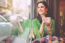 A young woman smiling after checking her EQ Bank TFSA savings account balance.