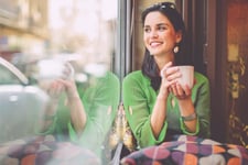 A young woman smiling after checking her EQ Bank TFSA savings account balance.