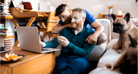 Couple sitting in front of computer smiling at screen