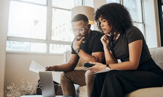 Two adults look at a laptop screen