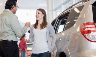 Car dealer handing woman keys