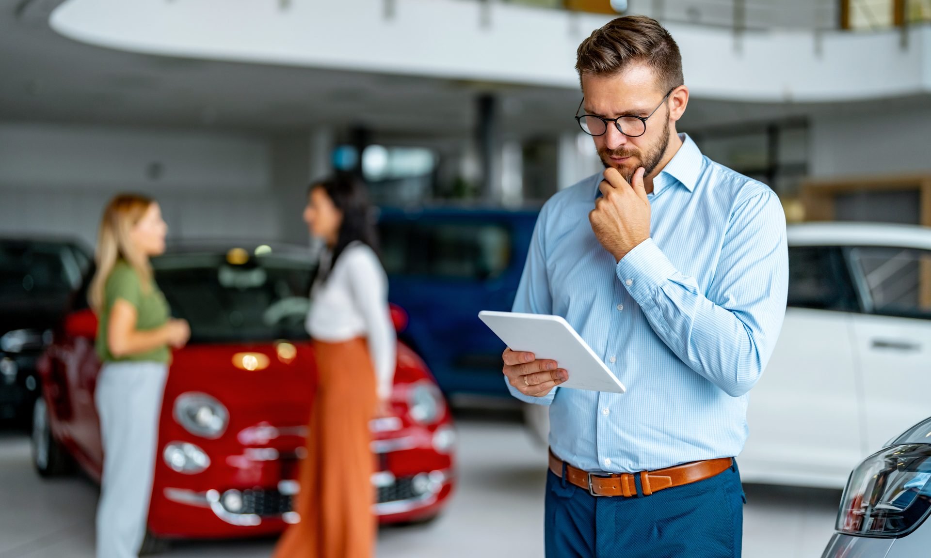 Person looking at tablet at car dealership