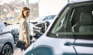 Woman browsing vehicles at a car dealership