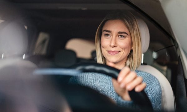 Happy woman driving a car