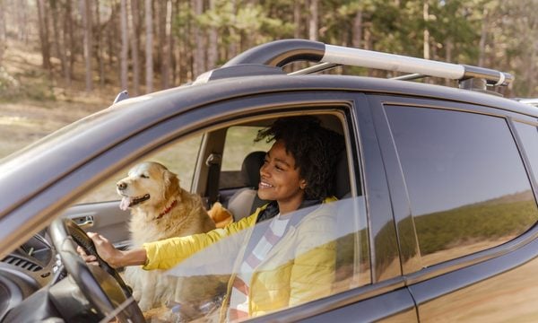 Woman driving car with dog
