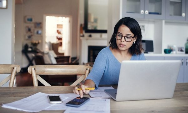 Person using a calculator and sitting at table