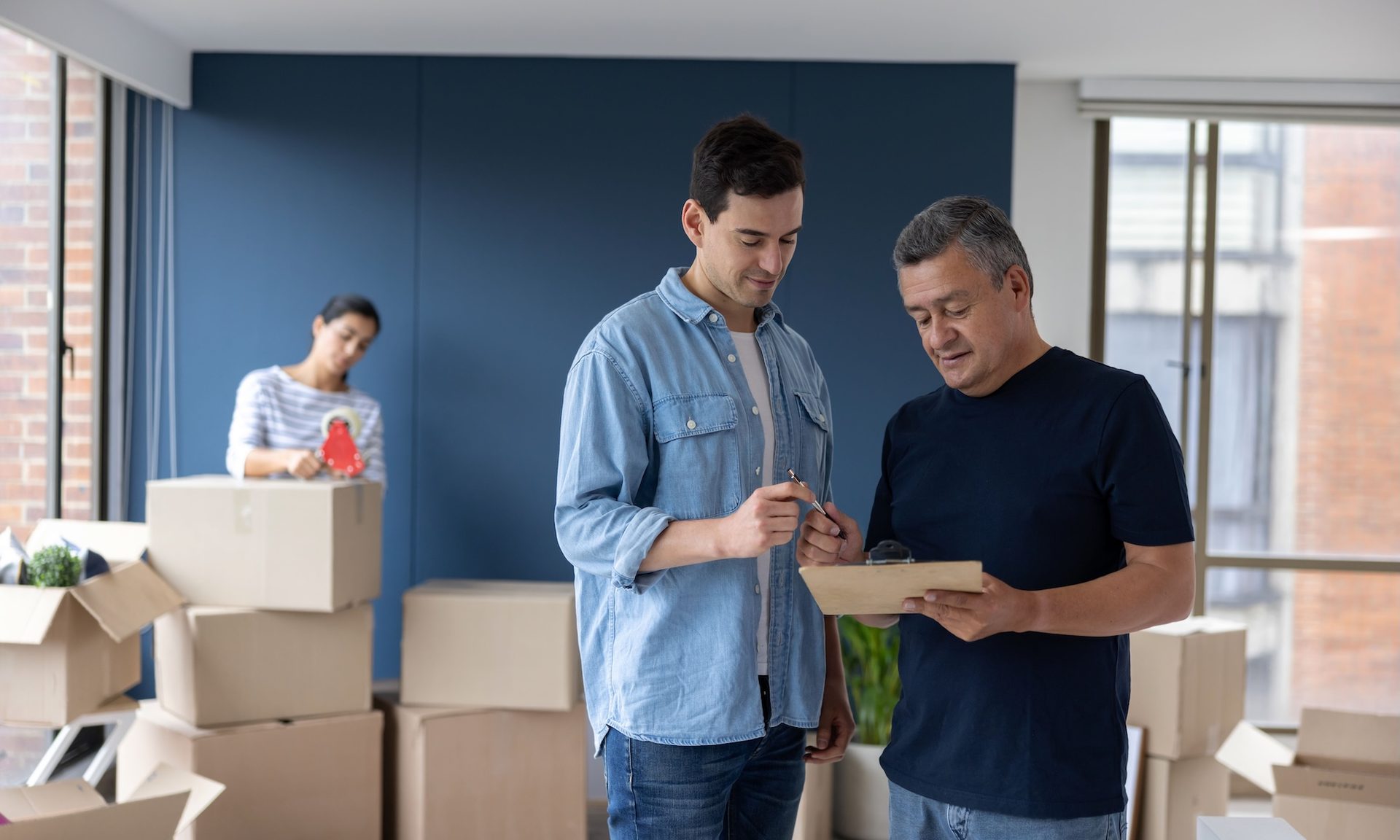 Man in home talking to moving company employee.