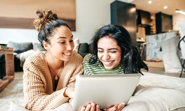 roommates laughing on living room floor