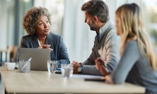 Three people talking at desk