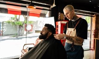 Barber putting a cape on the customer at a barber shop