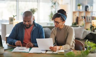 Black couple with planning or household budget in home.