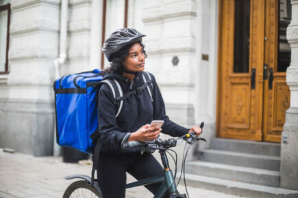 Female gig economy worker using bike to make deliveries