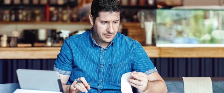 Male cafe owner worrying about late payments