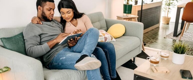 Couple looking at remortgaging fees on sofa