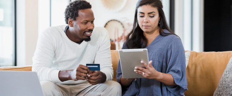 Couple at home transferring their credit card balance