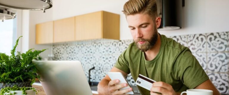 Man looking at his credit card to pay online